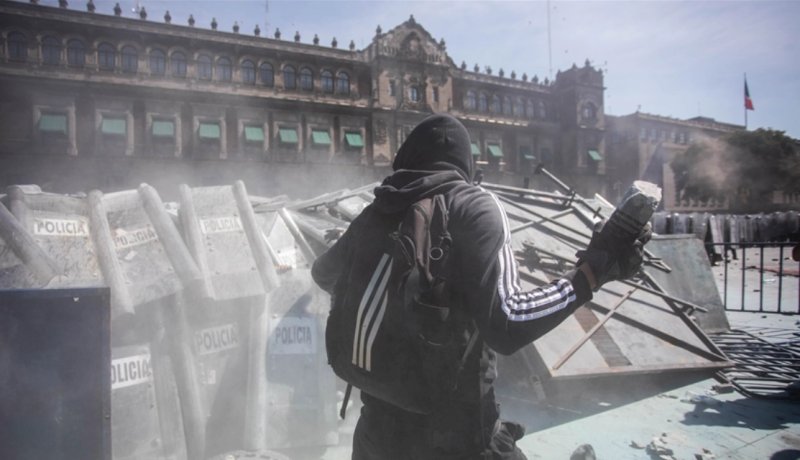 Protesters march in Mexico City during annual military parade 