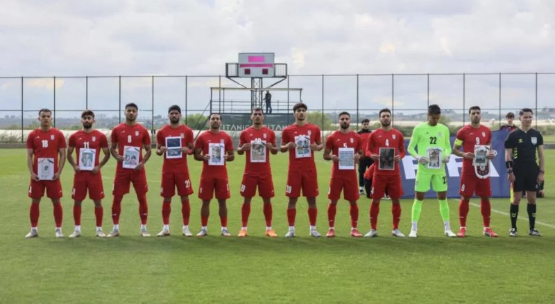 Iranian footballers in Türkiye hold photos of young victims of war