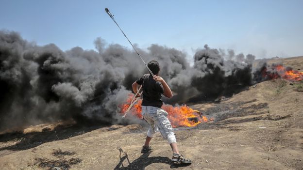 Tension in Gaza as Palestinians begin to bury 58 dead