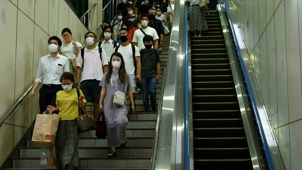 Japan to expand virus emergency to battle surge
