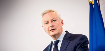 French economy minister crashes into a cyclist after running a red light